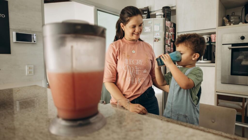 Mother and child sharing a smoothie in the kitchen – part of the 5-minute smoothie secret.